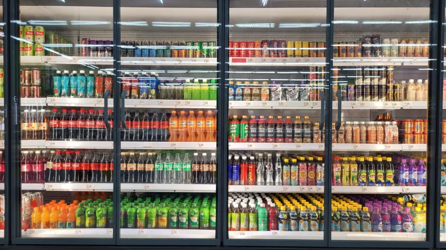 Beverage cooler shelves with multiple drinks, prices, and product facings